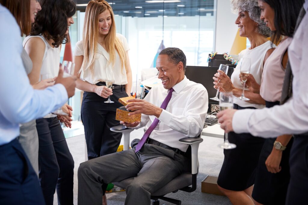 Coworkers celebrating a colleague’s retirement in the office