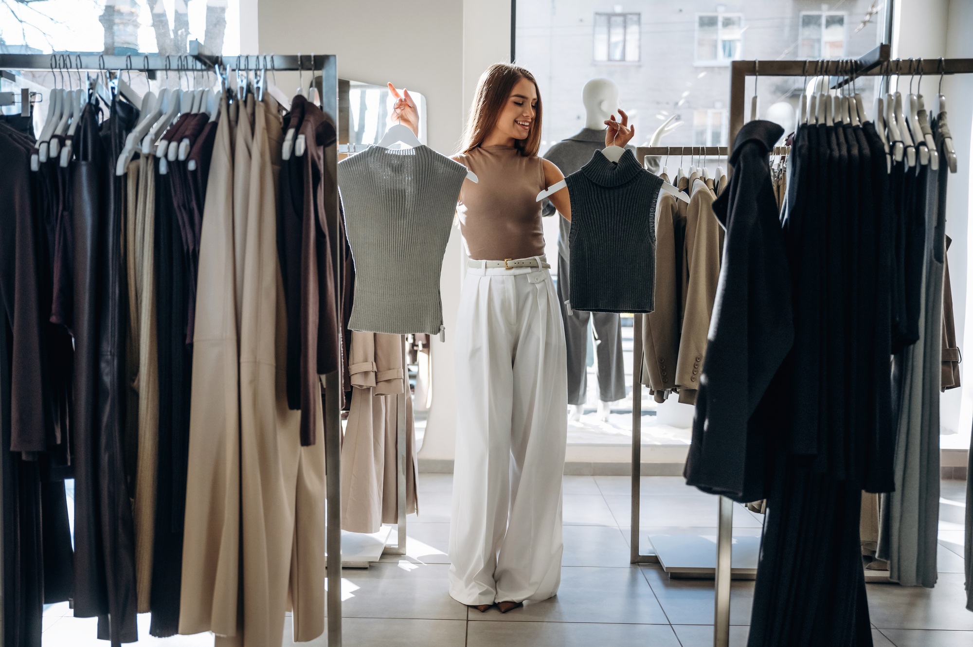 Making the choice. Woman chooses clothes in retail store