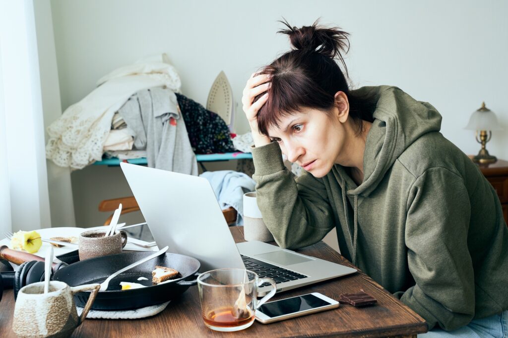 Digital addiction, woman in panic reads articles about coronavirus on Internet, abandoned household