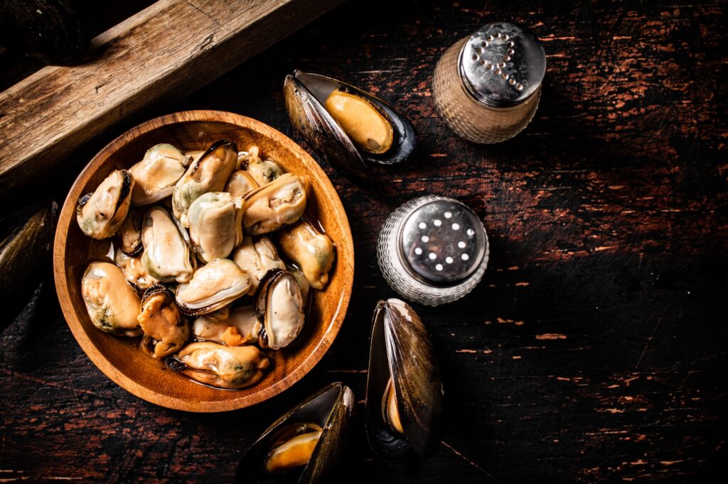 Pickled mussels in a wooden plate on the table.
